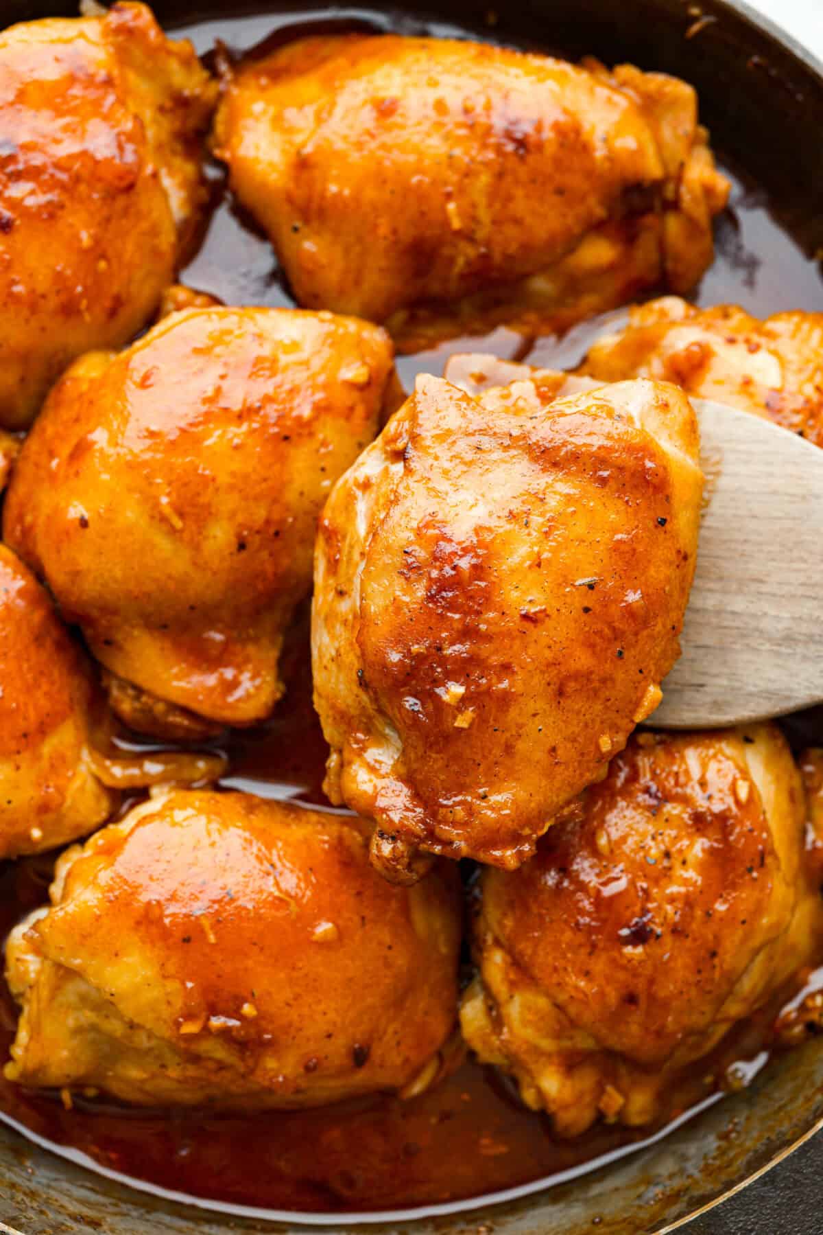 Close up shot of coca-cola chicken thighs in a skillet. 