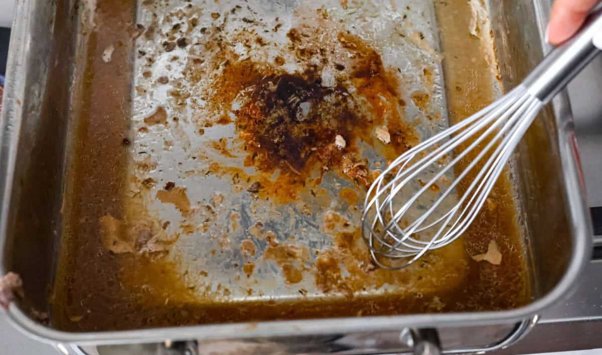 Overhead shot of deglazing the drippings from the turkey pan. 