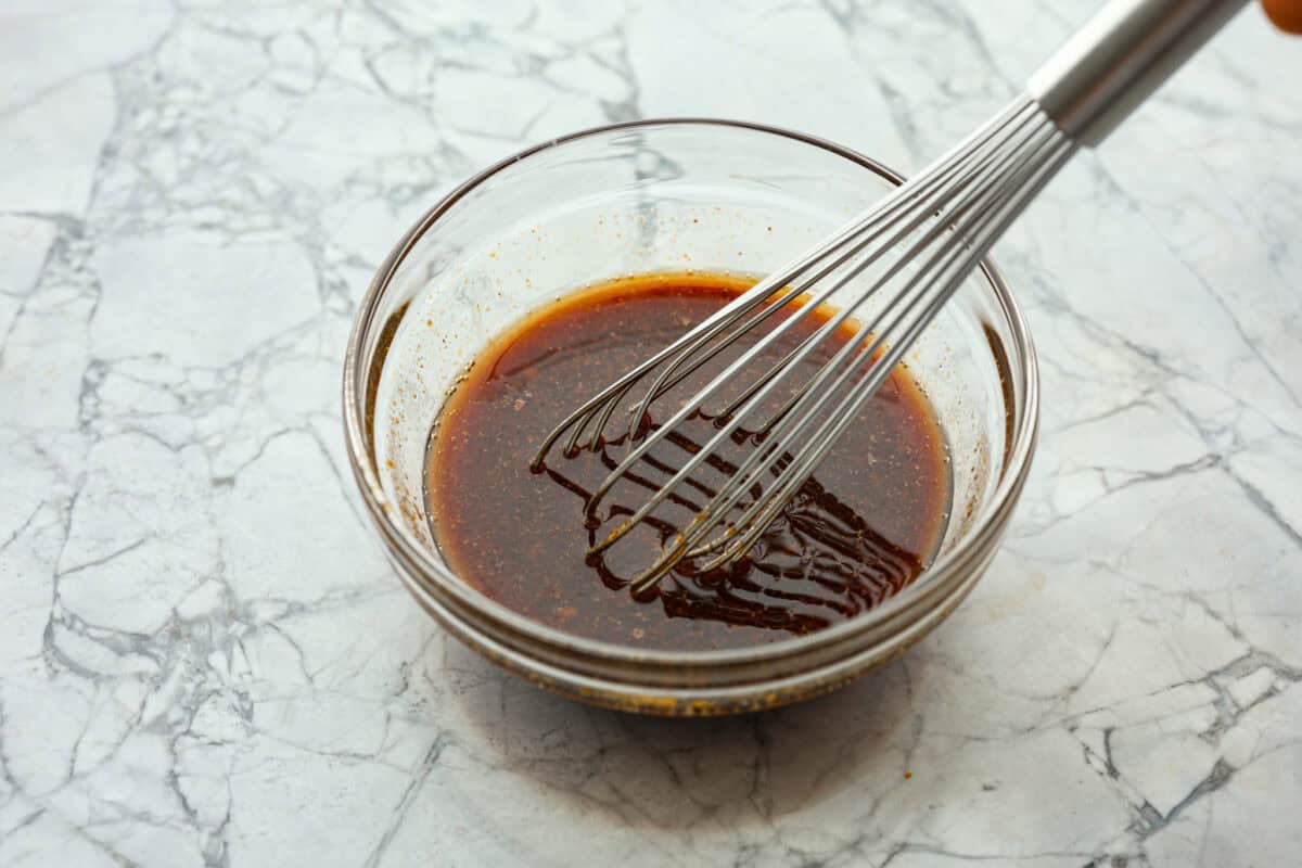 Angle shot of sauce ingredients whisked in a small bowl. 