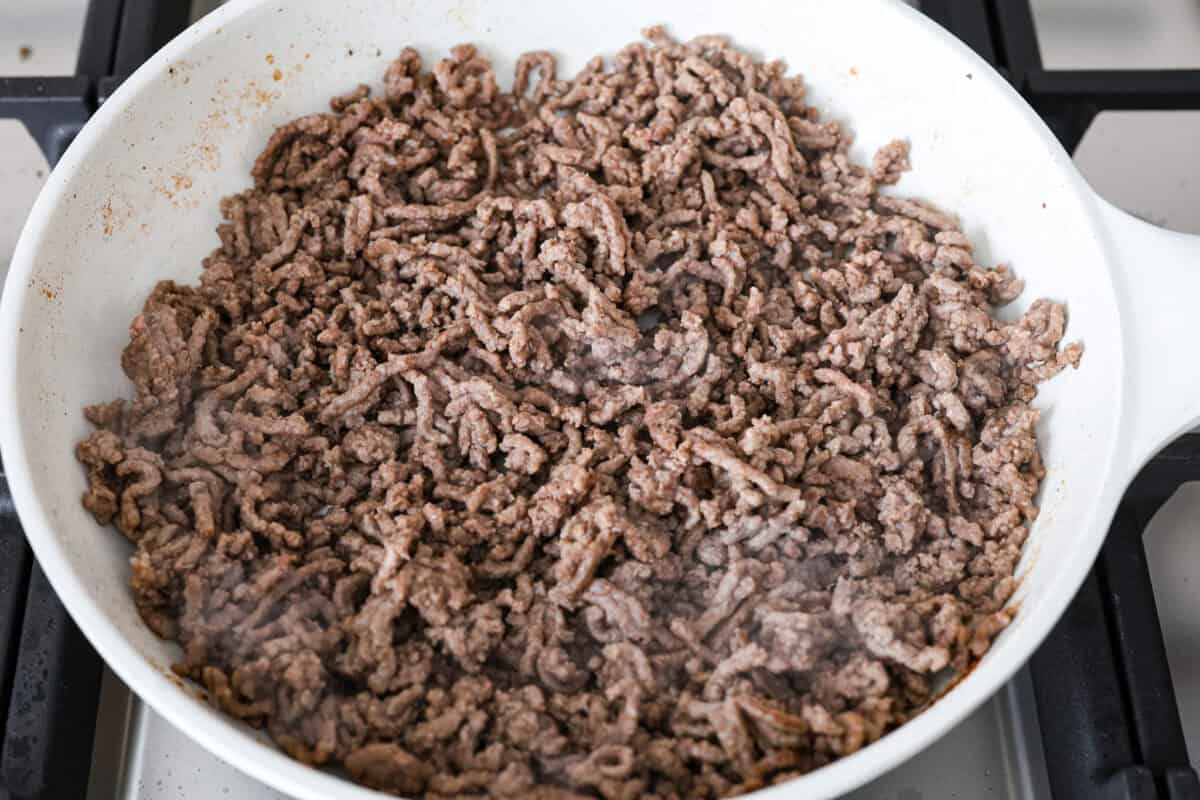 Overhead shot of beef browning in a skillet. 