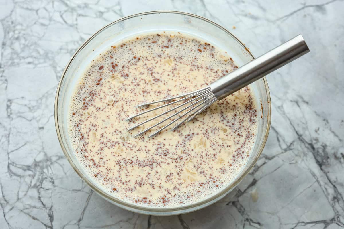 Pancake Casserole is a fun new Christmas or Easter breakfast idea. It has lots of buttery pancakes soaked overnight in a creamy custard, is baked to perfection, and served with your favorite toppings! Overhead shot of custard ingredients whisked together in a bowl.