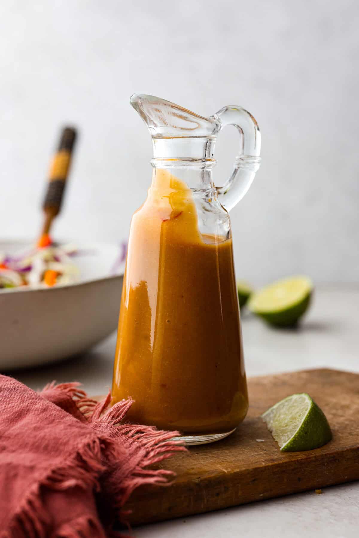 Side shot of Thai peanut dressing in a glass container. 