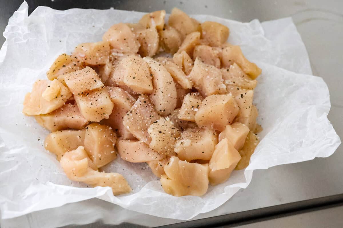 Overhead shot of cubed and seasoned chicken pieces. 