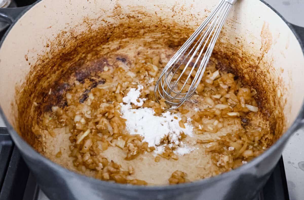 Angle shot of flour, butter and onion in a pot. 