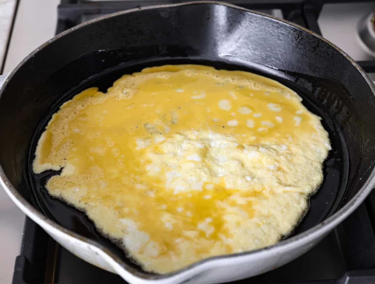 Angle shot of whisked eggs cooking in a skillet. 