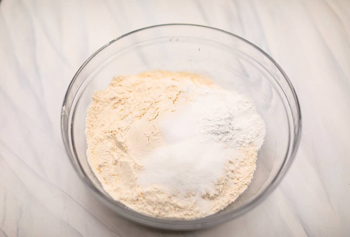 Biscuit Cinnamon Rolls are the most amazing twist on a classic! They are perfectly light, fluffy, and packed with cinnamon. The texture is more flakey and moist than traditional cinnamon rolls! Whether it’s for a cozy weekend breakfast or a holiday brunch, these hit the spot! Overhead shot of dry ingredients in a glass bowl.