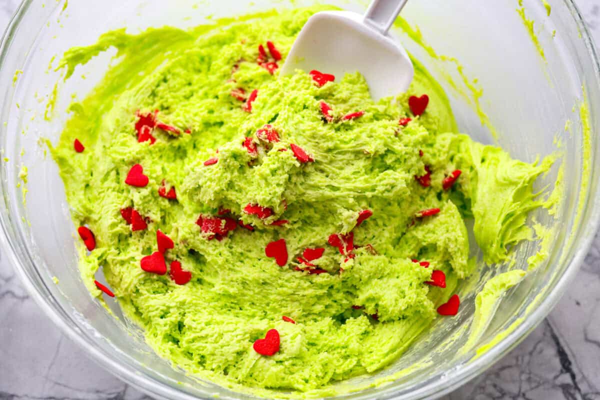 Overhead shot of someone folding in heart shaped sprinkles into the dip. 