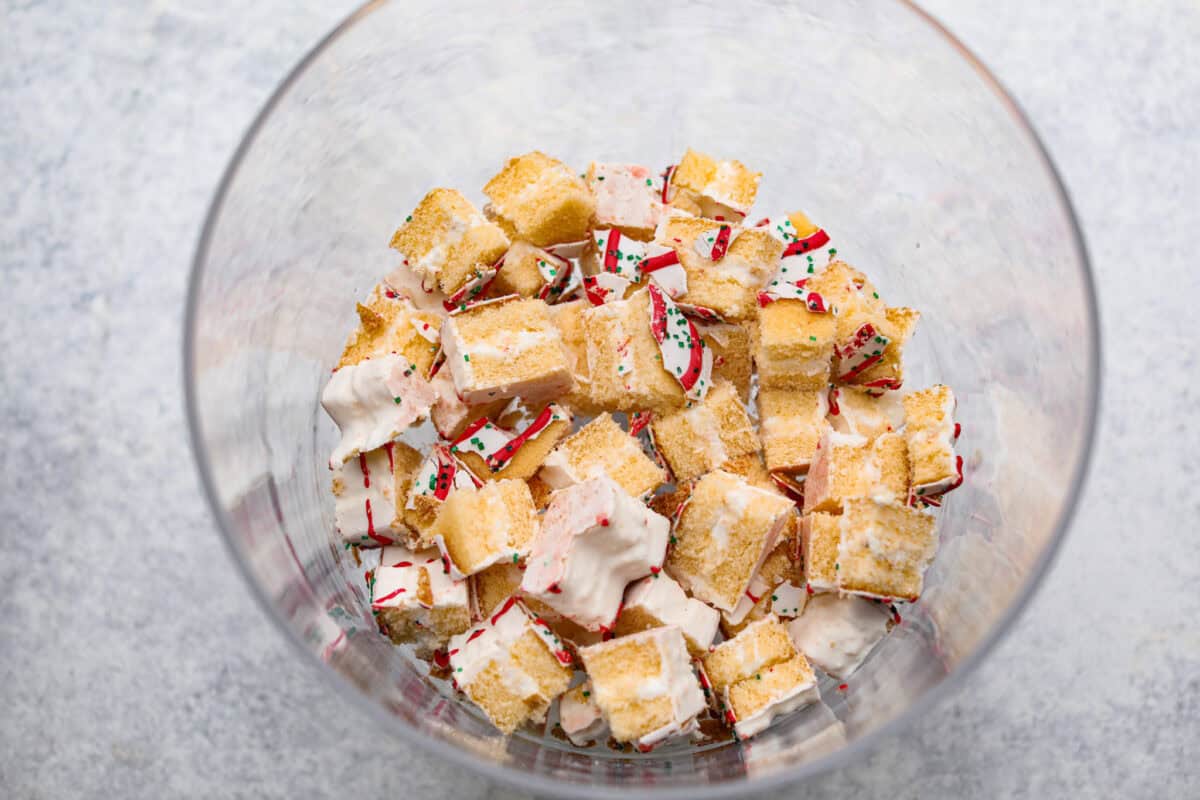 Overhead shot of Christmas tree cakes on the bottom of trifle dish.