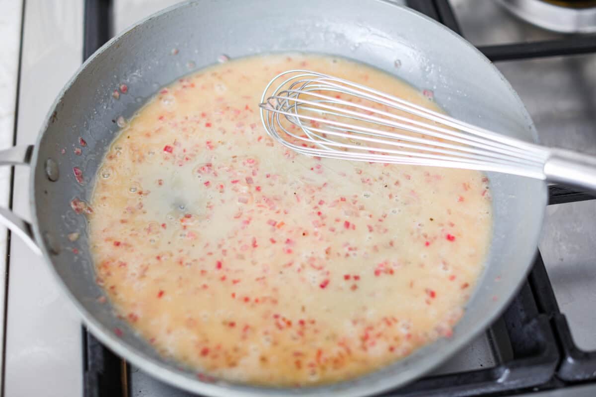 Overhead shot of rosemary chicken sauce simmering in a skillet. 