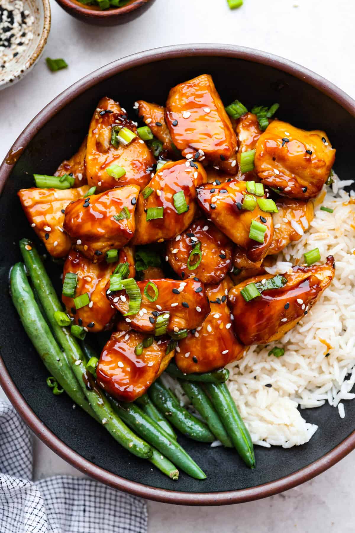 Overhead shot of plated air fryer teriyaki chicken next to green beans and rice. 