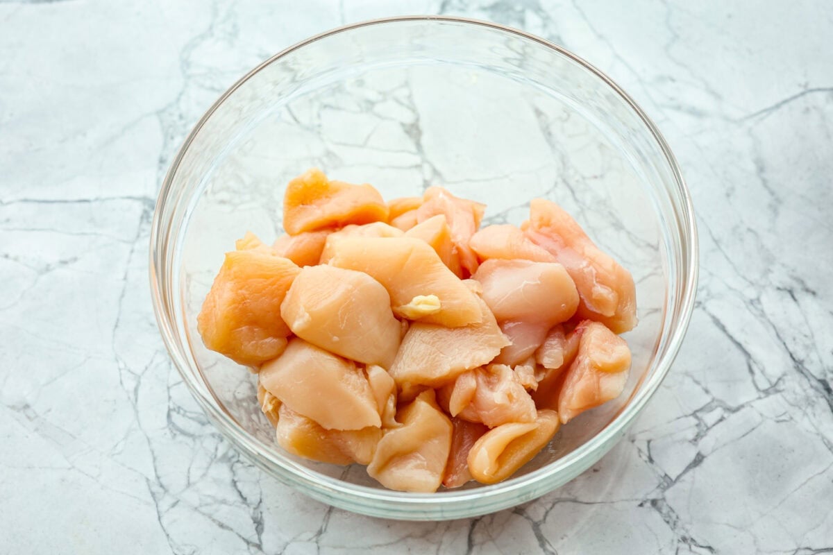 Overhead shot of cut up chicken breast in a bowl. 