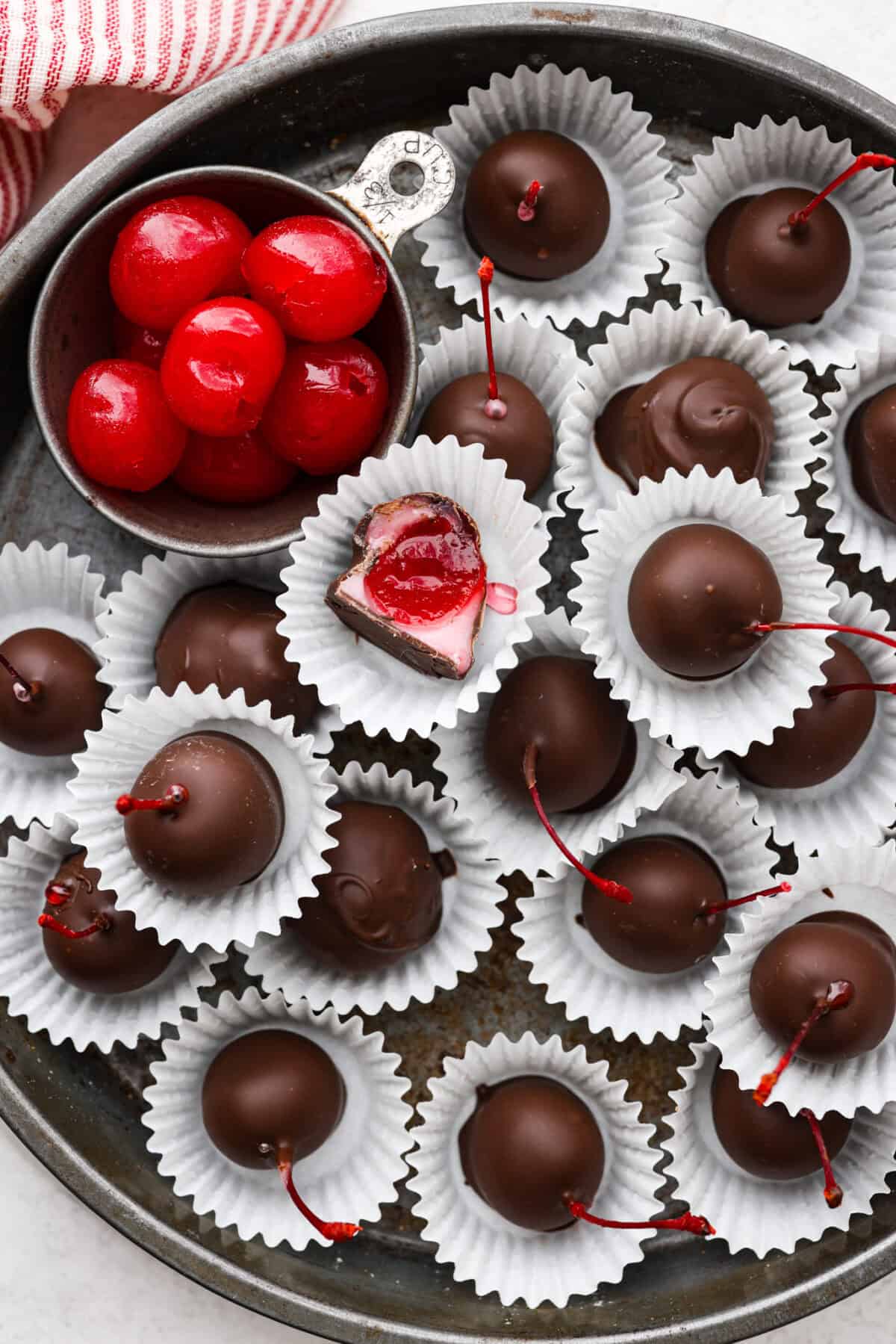 Overhead shot of cherry cordials in paper wrapping on a serving platter. 