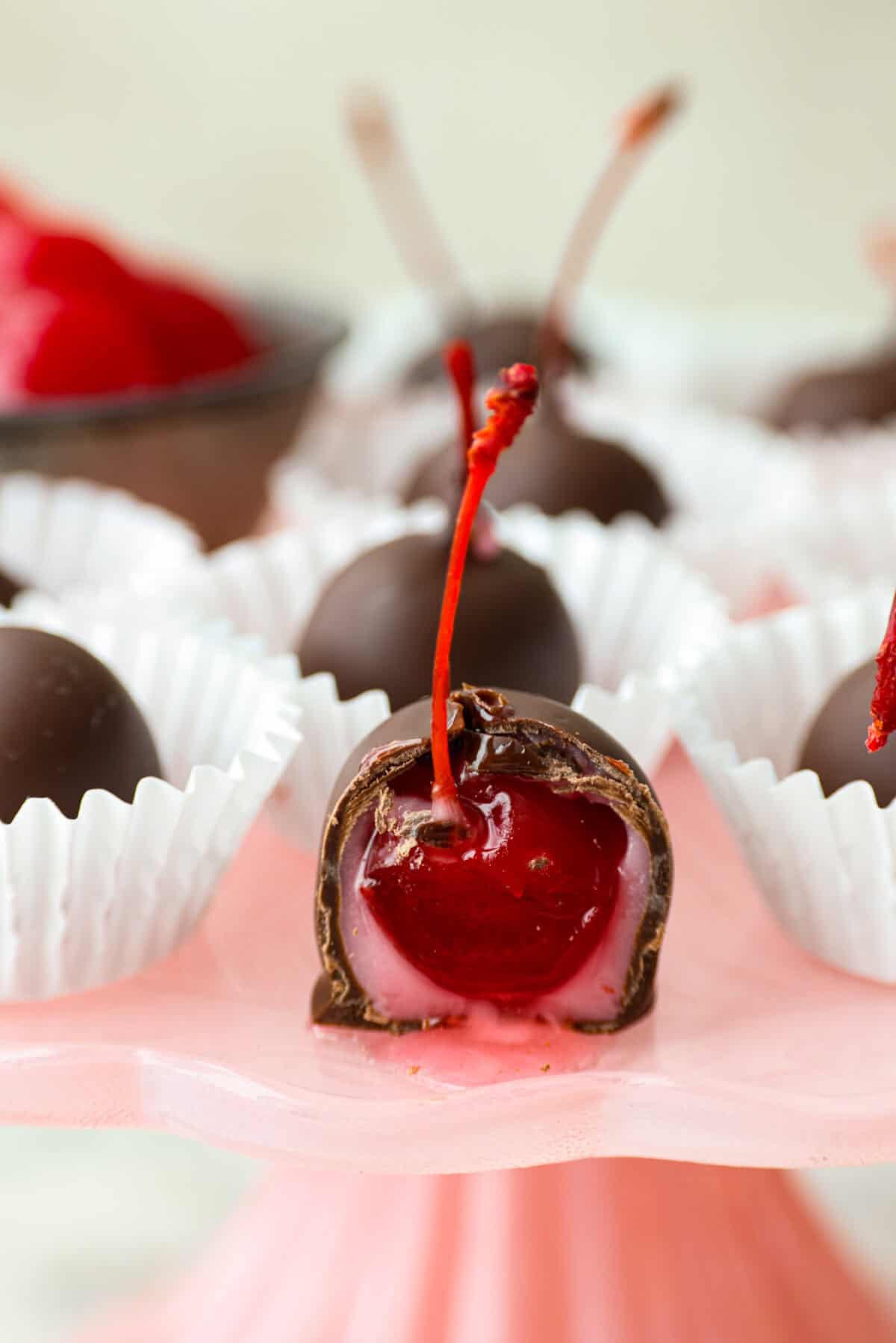 Close up shot of a cherry cordial with a bite taken out of it. 