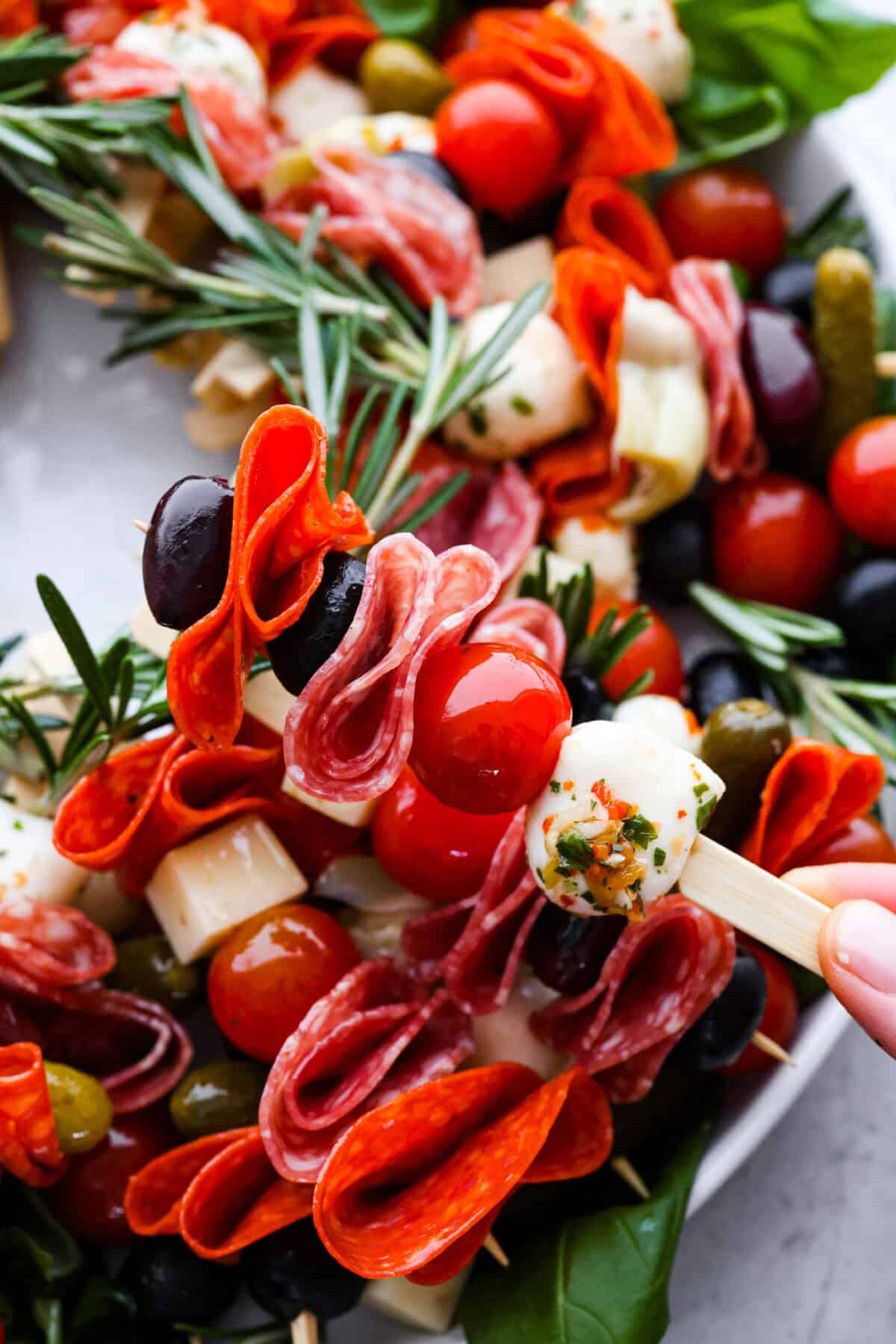 Close view of a skewer full of antipasto ingredients. 