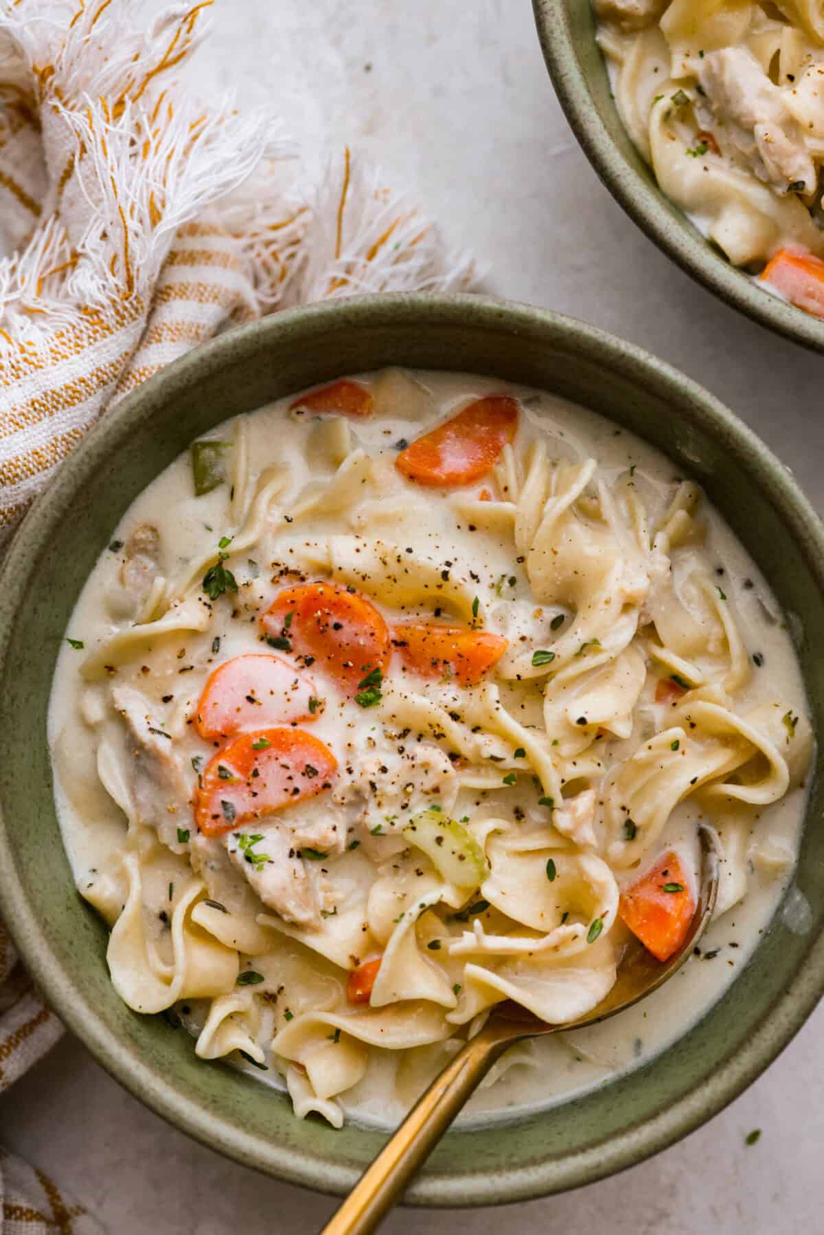 Overhead shot of a bowl of creamy chicken noodle soup. 