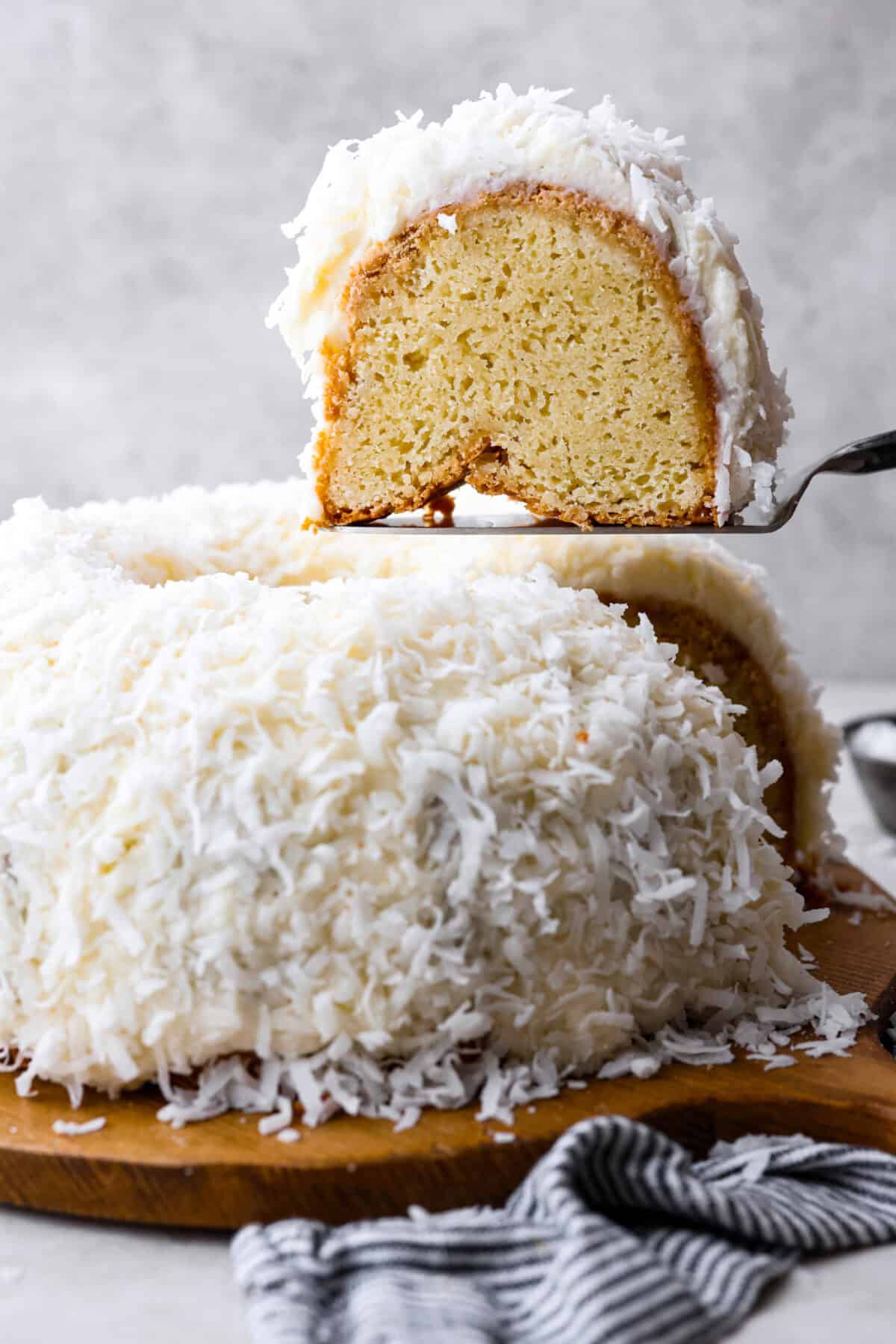 Side view of tom cruise coconut cake with a piece being lifted out.