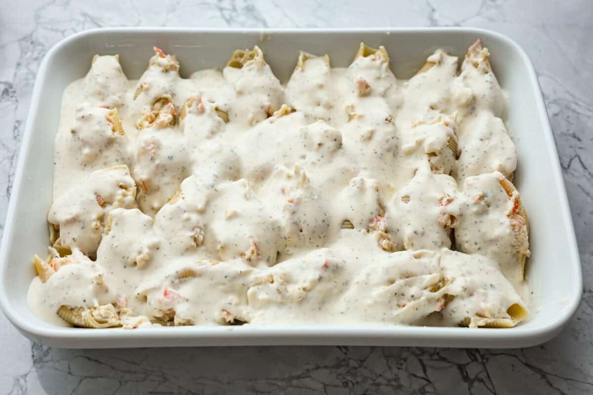 Overhead shot of all the pasta shells stuff and covered in Alfredo sauce. 