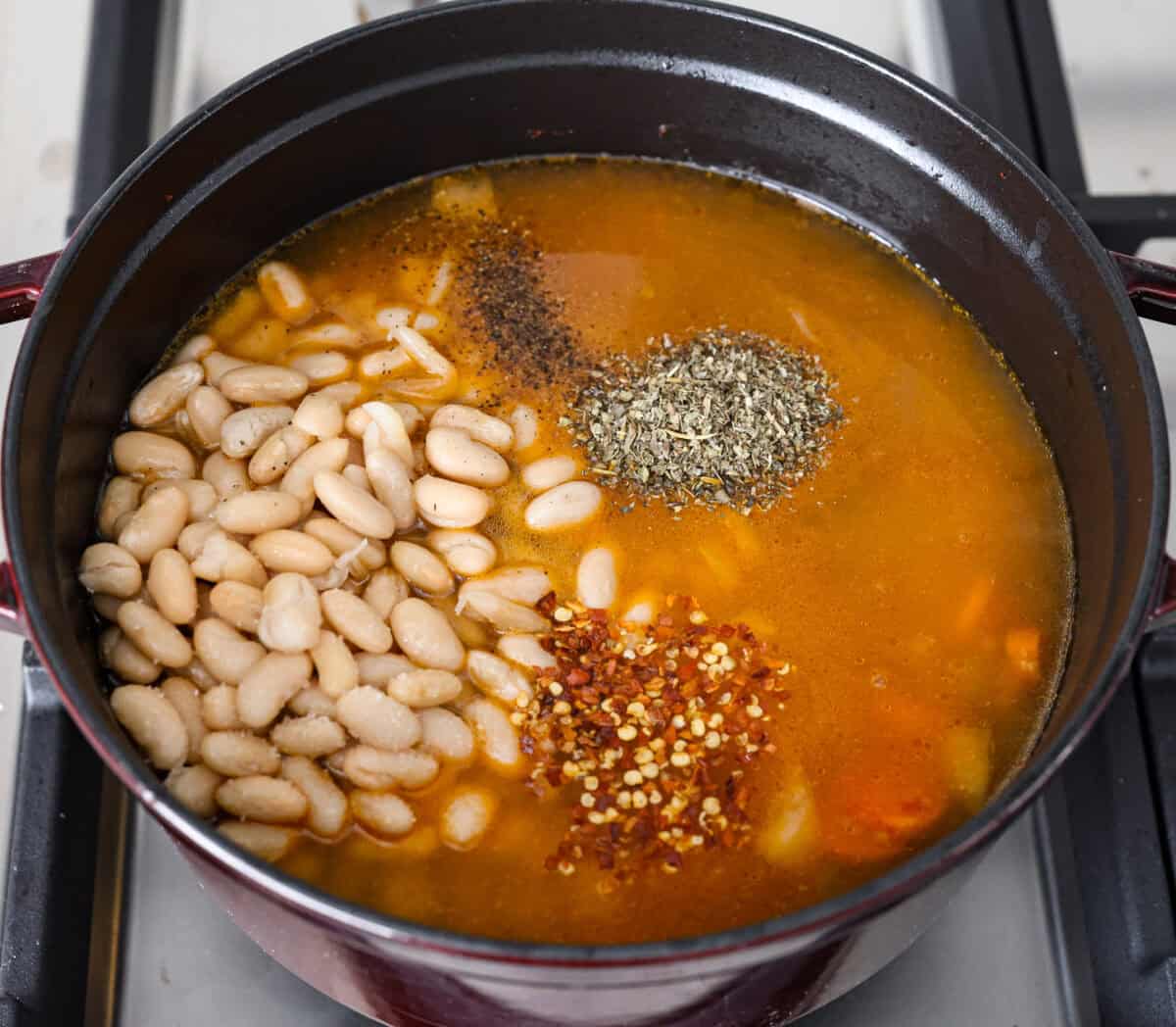 Overhead shot of beans, stock, seasonings and vinegar added. vegetable. 