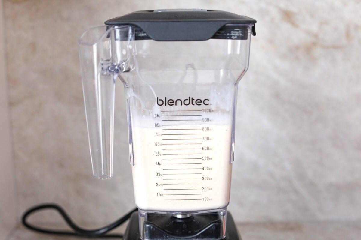 Side shot of a blender with all of the ingredients blended up inside. 