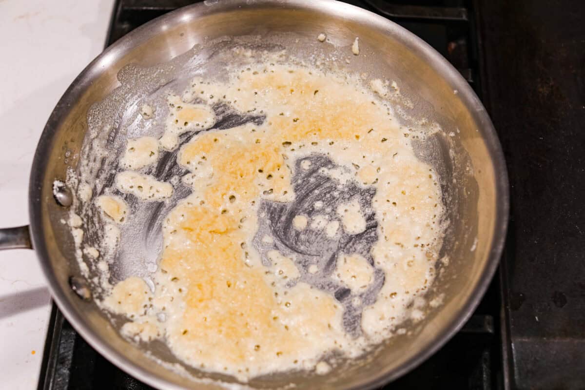 Overhead shot of butter and flour cooking in a pan on the stove. 