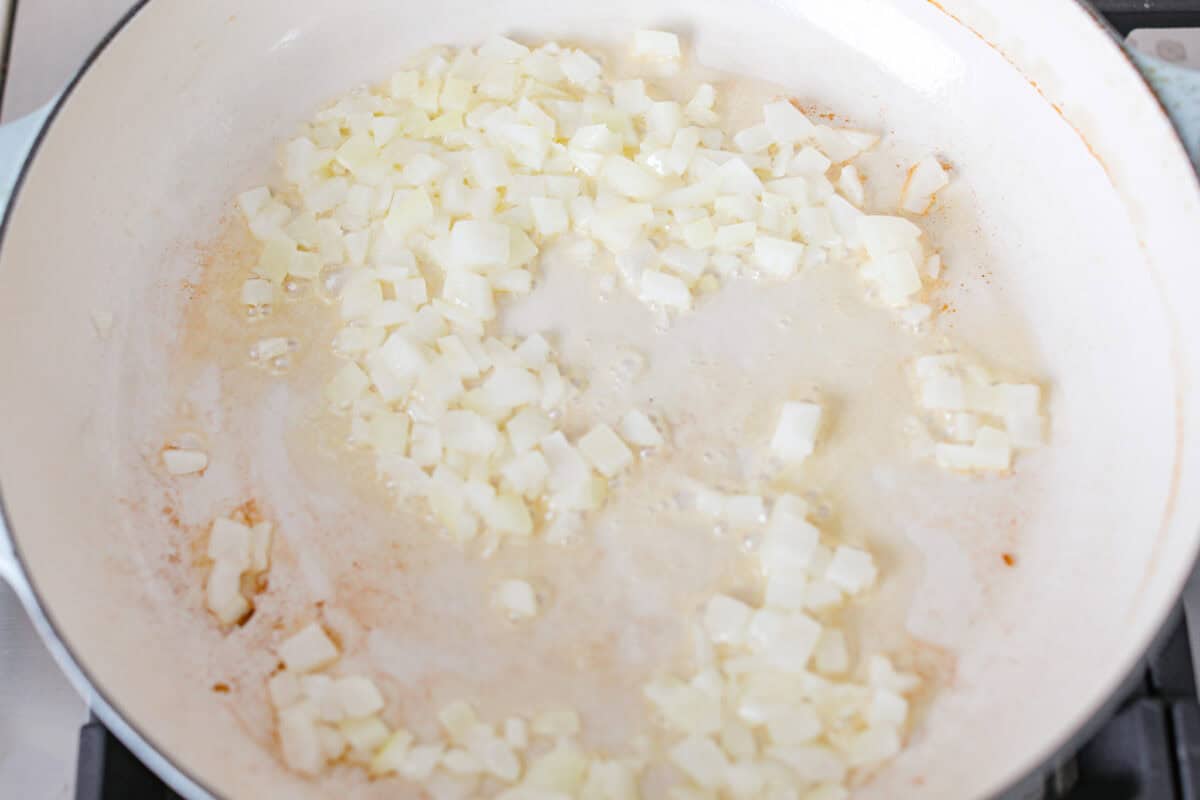 Overhead shot of onions cooking in a skillet. 