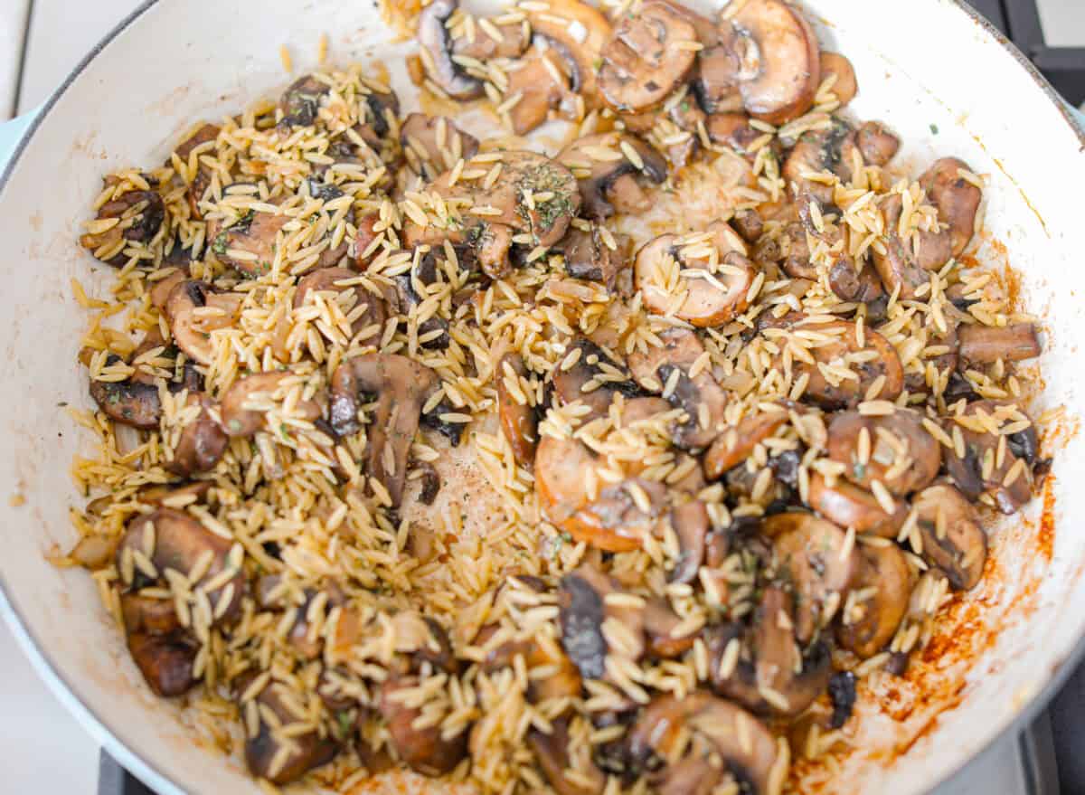 Overhead shot of the cooked mushrooms with seasonings and orzo added. 