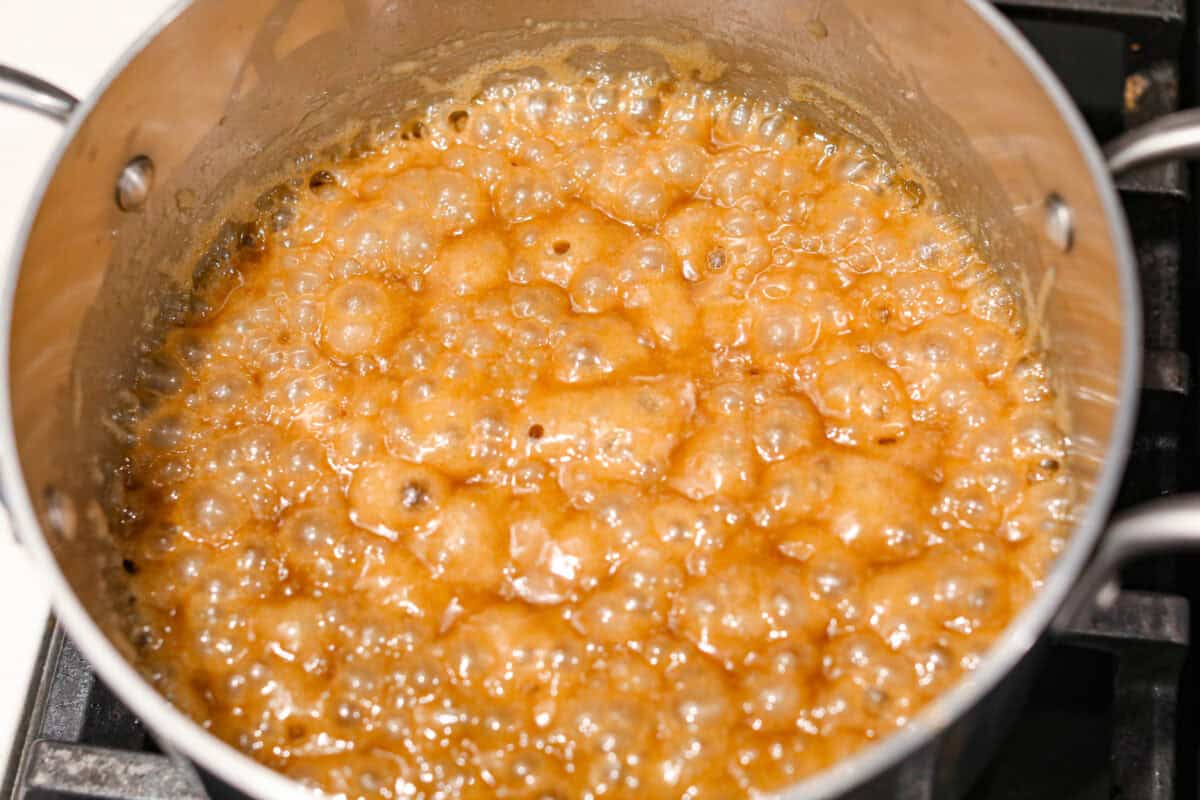 Overhead shot of caramel mixture boiling in a saucepan. 