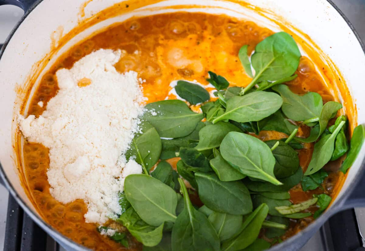 Overhead shot of the cream, cheese and spinach added to the rest of the soup. 