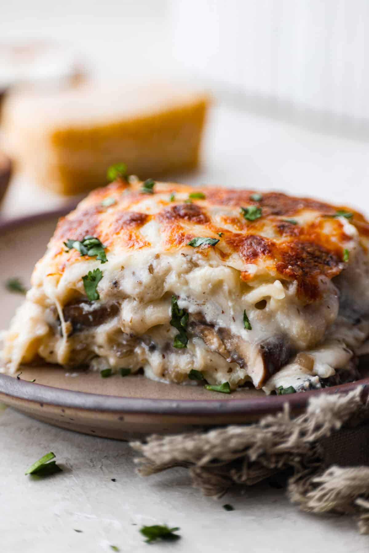 Side shot of a plated slice of mushroom lasagna. 