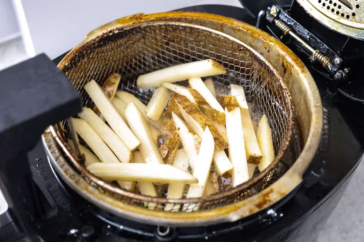 Steak Frites is a classic French bistro dish that combines perfectly seared, juicy steak with crispy, golden fries. It's a simple yet delicious meal that is filled with rich flavors and satisfying crunch. You will love this restaurant-quality dinner made right in your own kitchen! Angle shot of the sliced potatoes being fried.