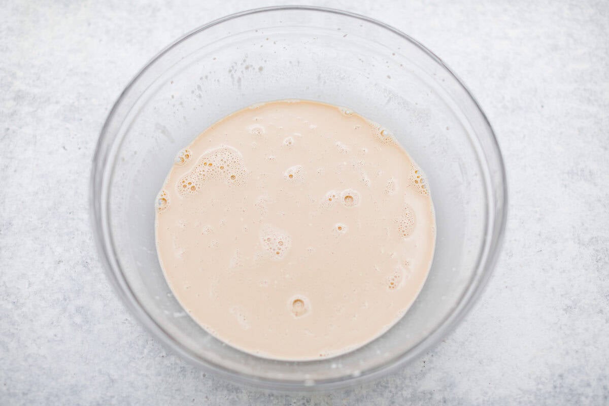 Overhead shot of mayonnaise, coffee, eggs and vanilla whisked together in a bowl. 