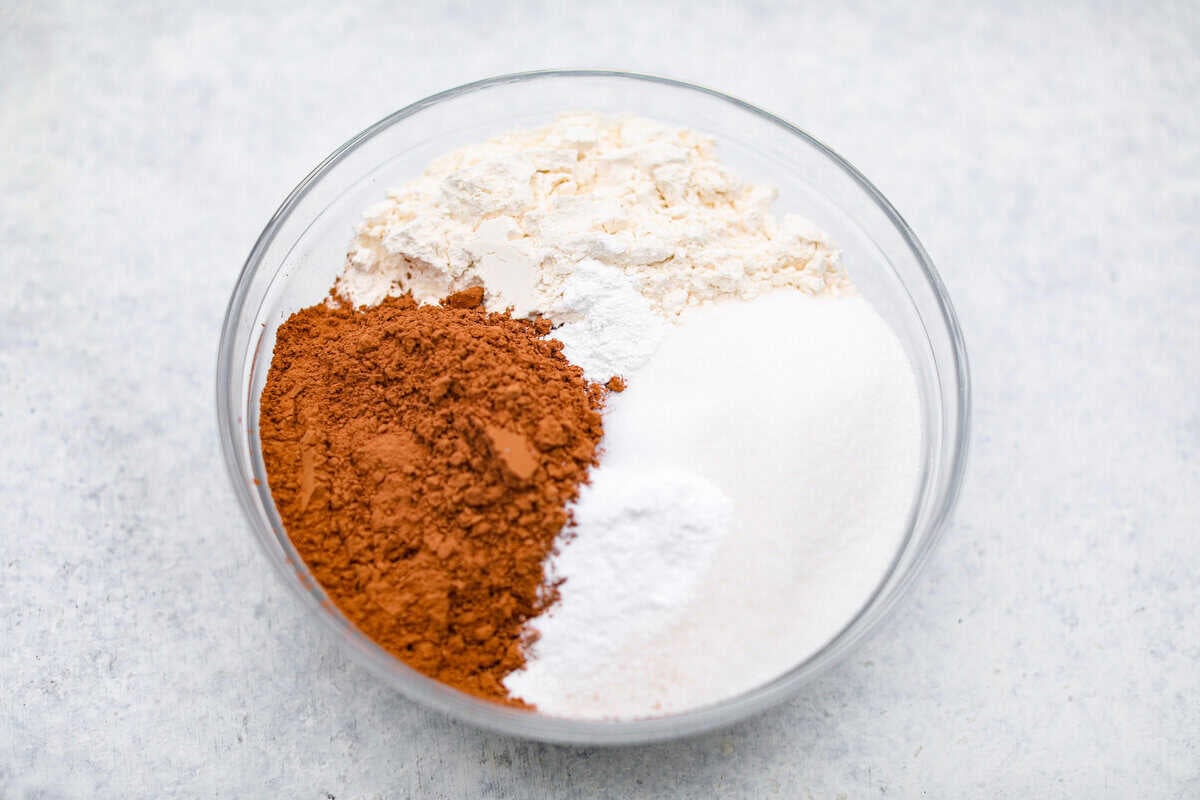 Chocolate Mayonnaise Cake is a rich, moist, and decadent dessert that’s super easy to make! The mayonnaise adds extra moisture and creates a soft, tender crumb. Whether for a special occasion or just because it's sure to impress! Overhead shot of flour, cocoa powder, and sugar in a bowl.
