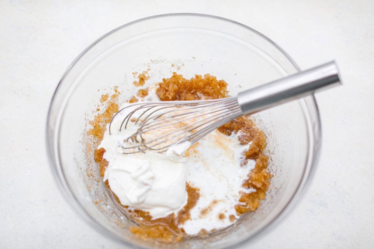 These double chocolate muffins are rich, moist, and packed with deep chocolate flavor! They are the perfect treat for breakfast, snack time, or dessert. They come together with simple ingredients and bake up beautifully with a soft, tender crumb in less than an hour! Sour cream and buttermilk added to the mixing bowl with the sugars and oil mixed together.
