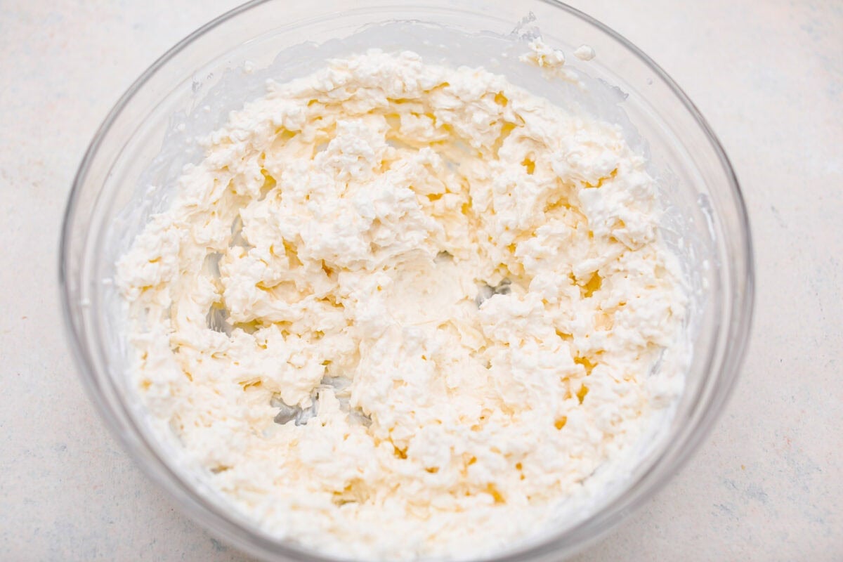 Overhead shot of cottage cheese, mozzarella, sour cream and cream cheese mixed together. 