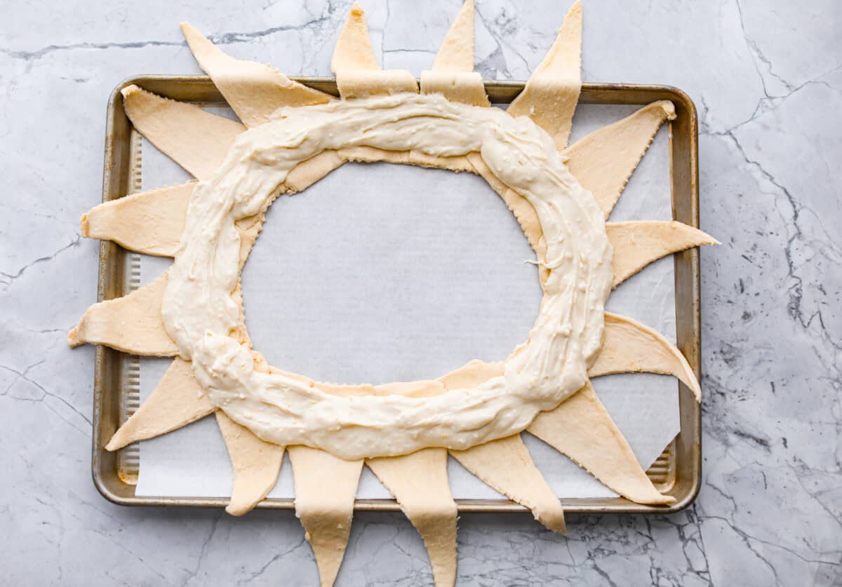 Overhead shot of the cream cheese filling spread in a ring on the sunburst crescent rolls. 