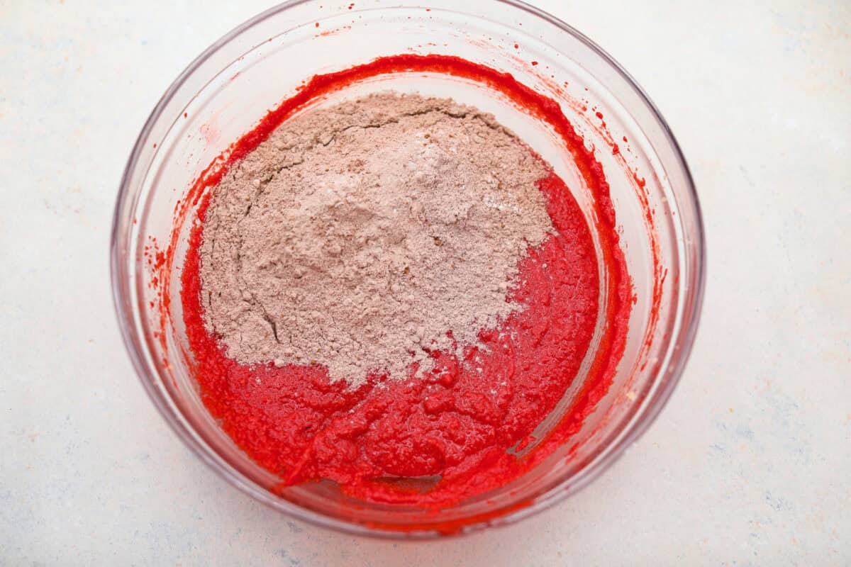 Dry ingredients added to the butter and food coloring mixture.