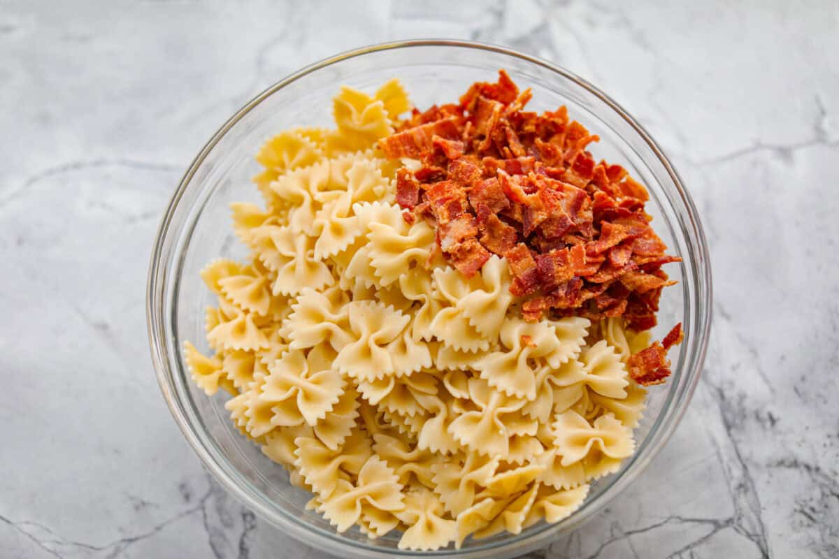 Overhead shot of cooked  pasta, and bacon in a bowl. 