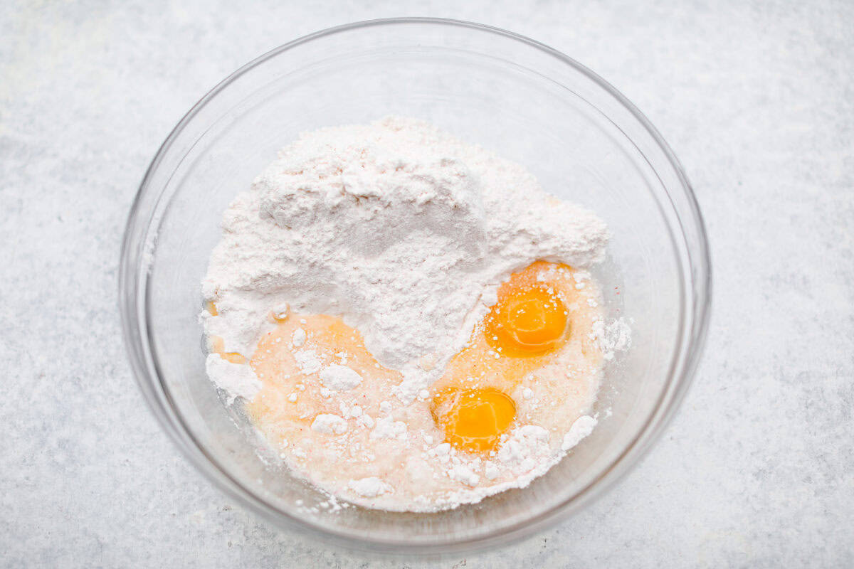 Overhead shot of the cake mix, eggs, and butter in a mixing bowl. 