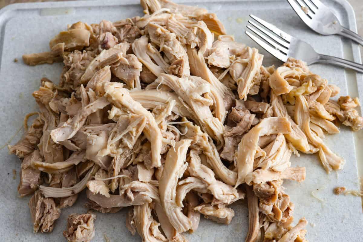 Overhead shot of the chicken shredded on a cutting board. 