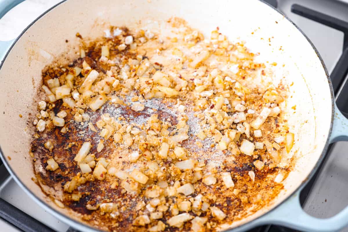 Overhead shot of onions and garlic sautéing in the skillet. 