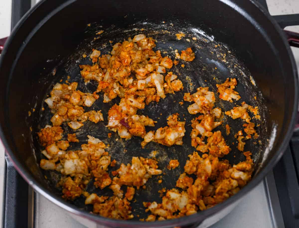 Overhead shot of cooked onion and garlic with flour and seasonings. 