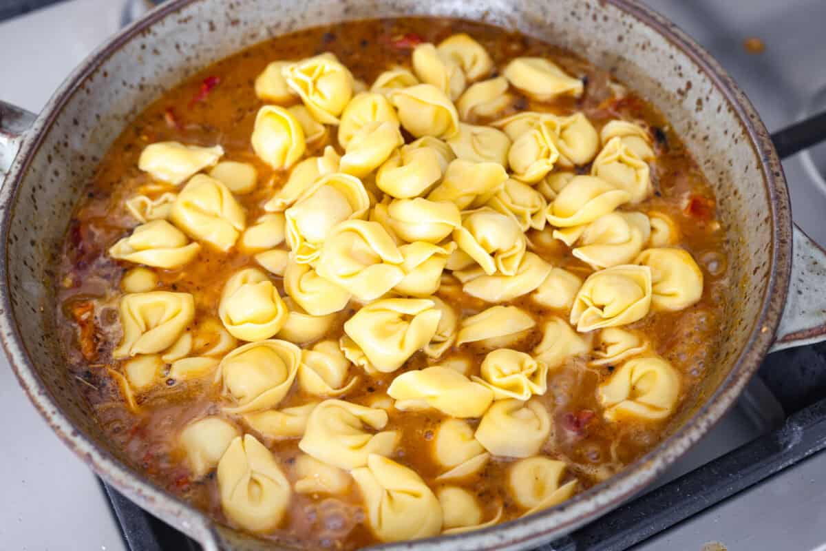 Overhead shot of the tortellini added  to the sauce. 