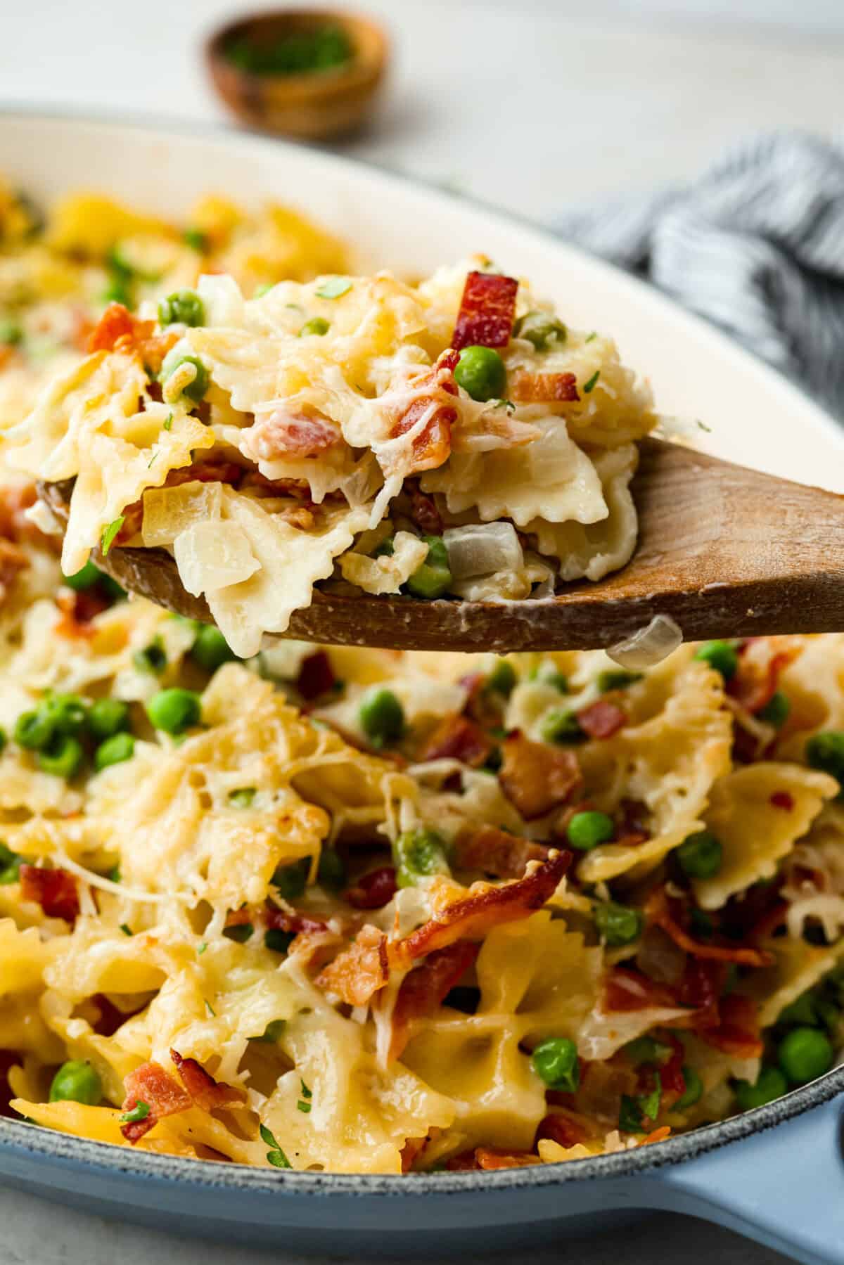 Close up shot of a scoop of Stanley Tucci pasta casserole on a wooden spoon. 