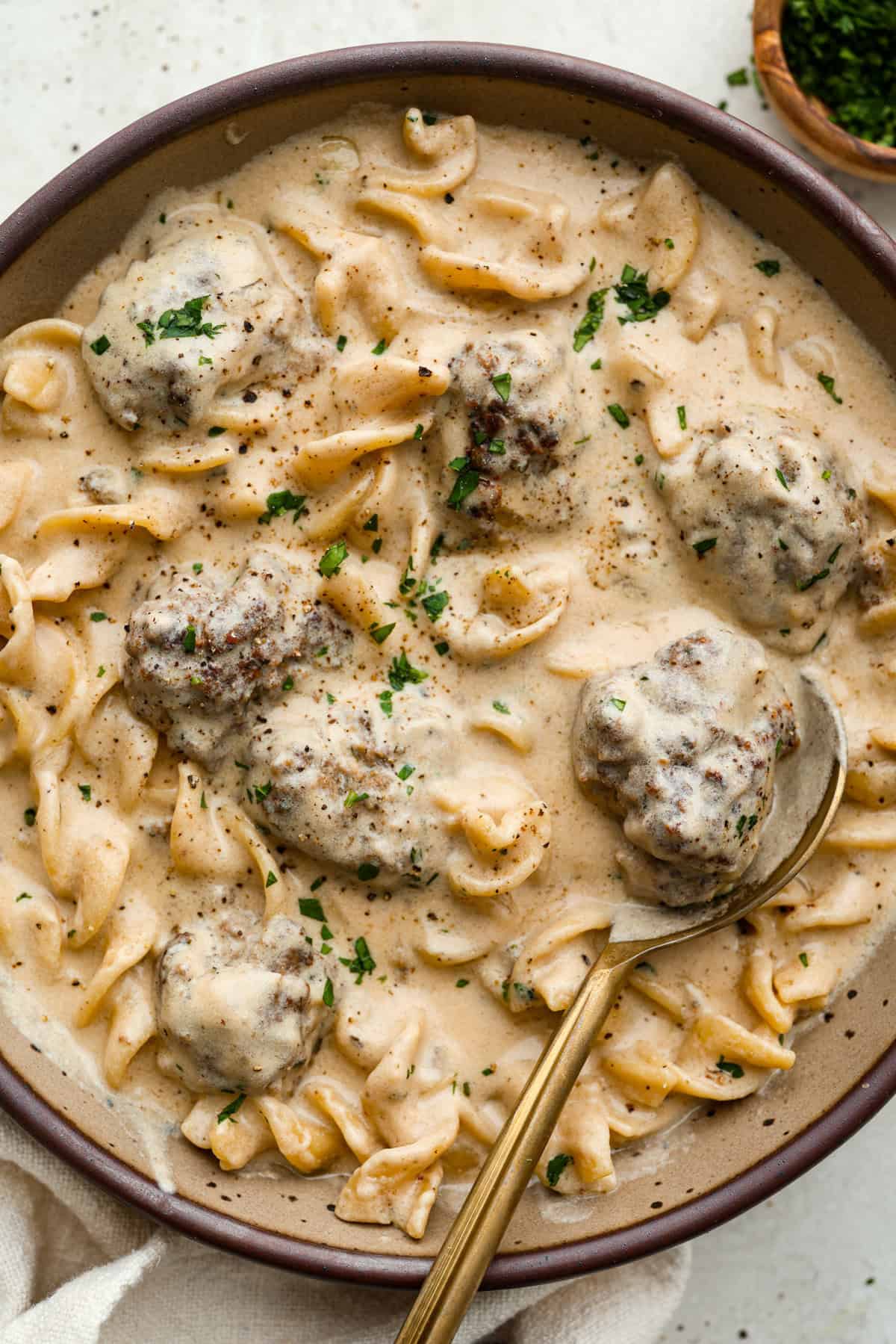 Warm and comforting, this cozy Swedish meatball soup is the perfect meal for chilly days. Juicy meatballs simmer in a rich, savory broth with tender noodles, making every spoonful satisfying. It’s easy to make and sure to become a family favorite! Overhead shot of plated Swedish meatball soup.
