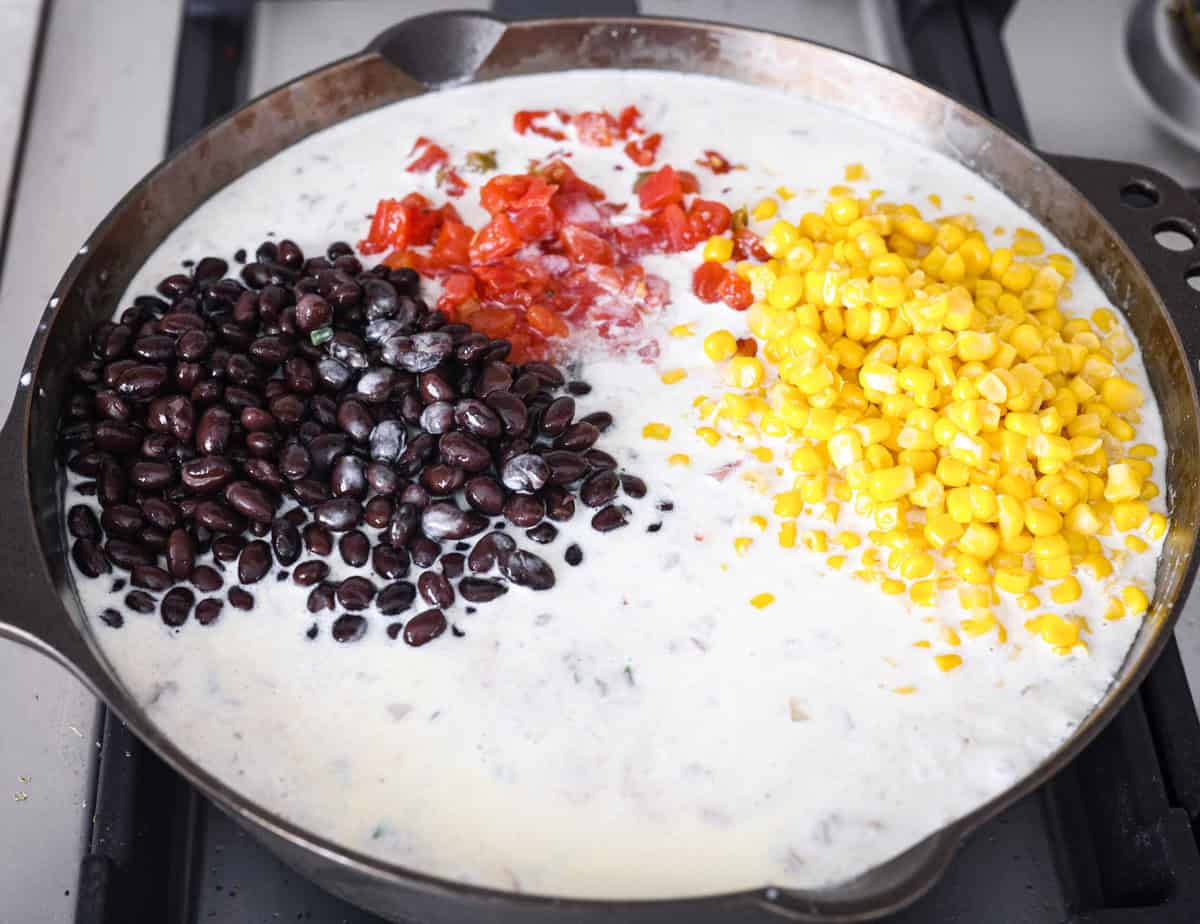 Creamy, cheesy Cowboy Mac and Cheese gets a bold twist with hearty additions like seasoned meat, tomatoes, jalapeños, corn, beans, and onions. It's rich, flavorful, and just the right amount of spice! The heat is warm but not overwhelming. If you like it spicy, add more jalapeños! Whole milk, black beans, corn and canned tomatoes with green chilies added to the skillet.