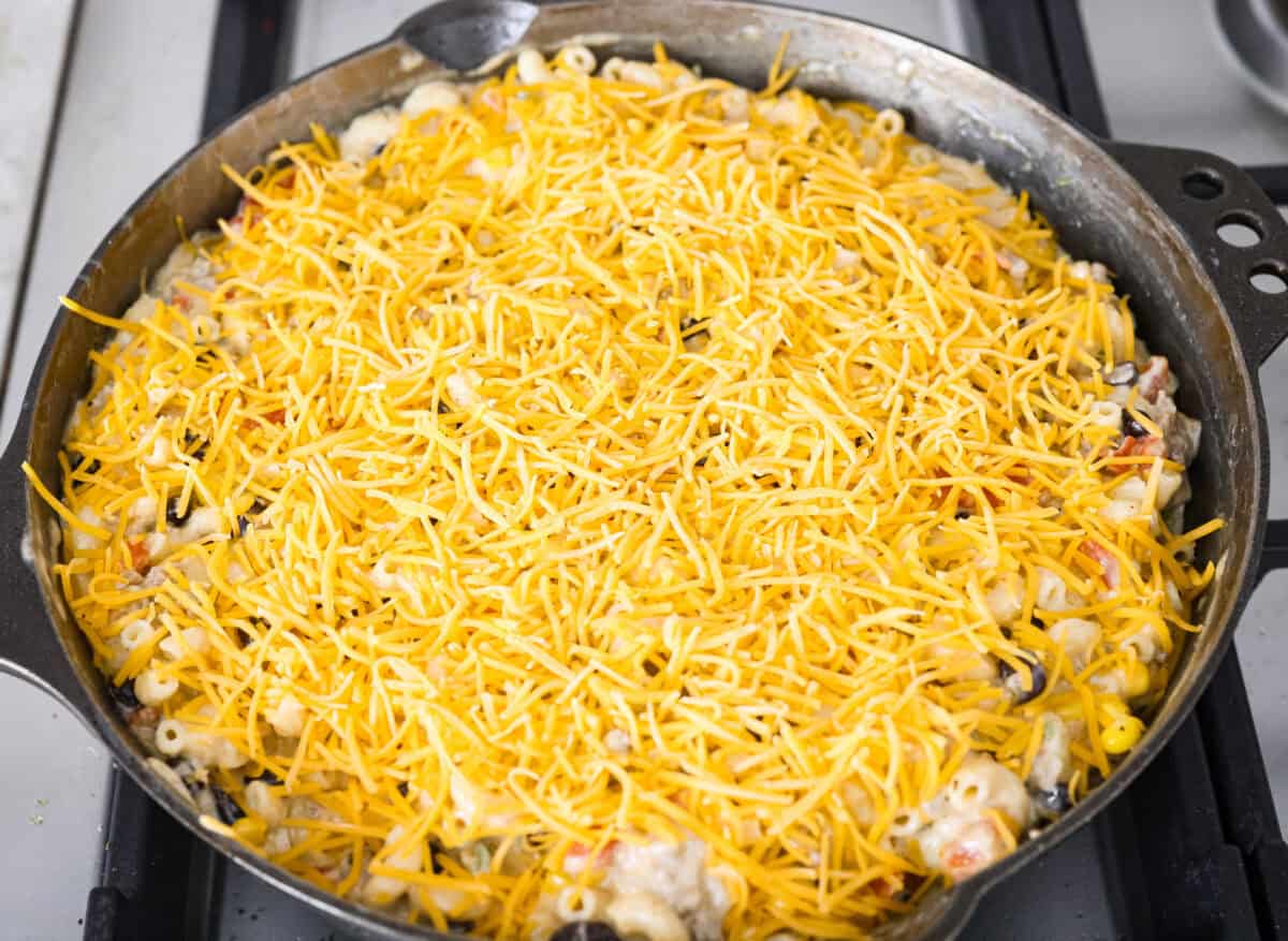 Everything is stirred together in a skillet and topped with shredded cheddar cheese. 