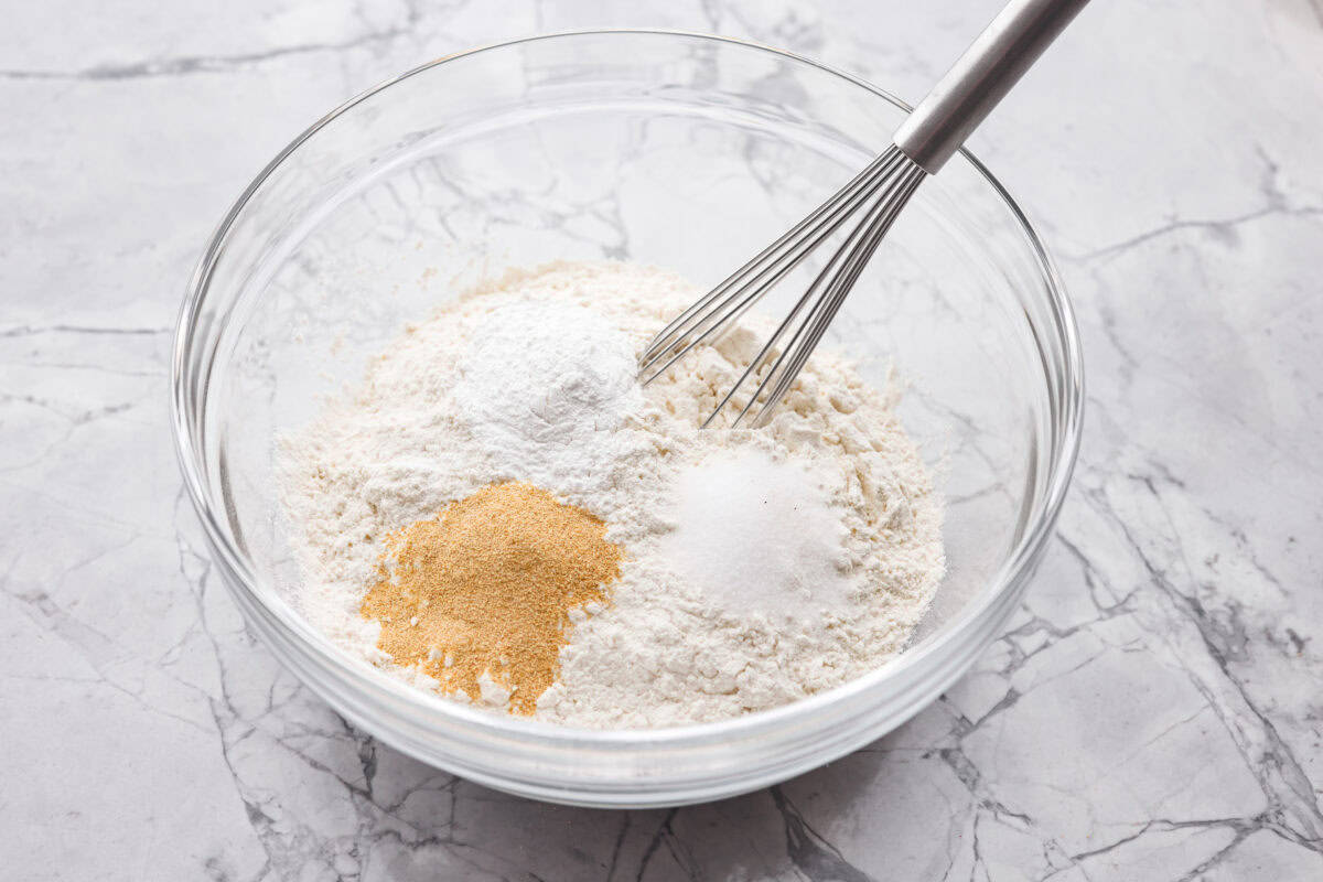 A mixing bowl filled with all of the dry ingredients and a whisk. 