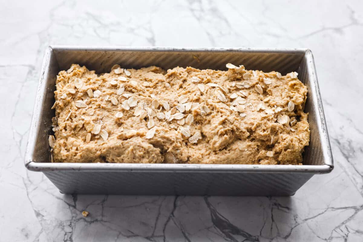 Overhead shot of the bread dough in a loaf pan ready to go into the oven. 