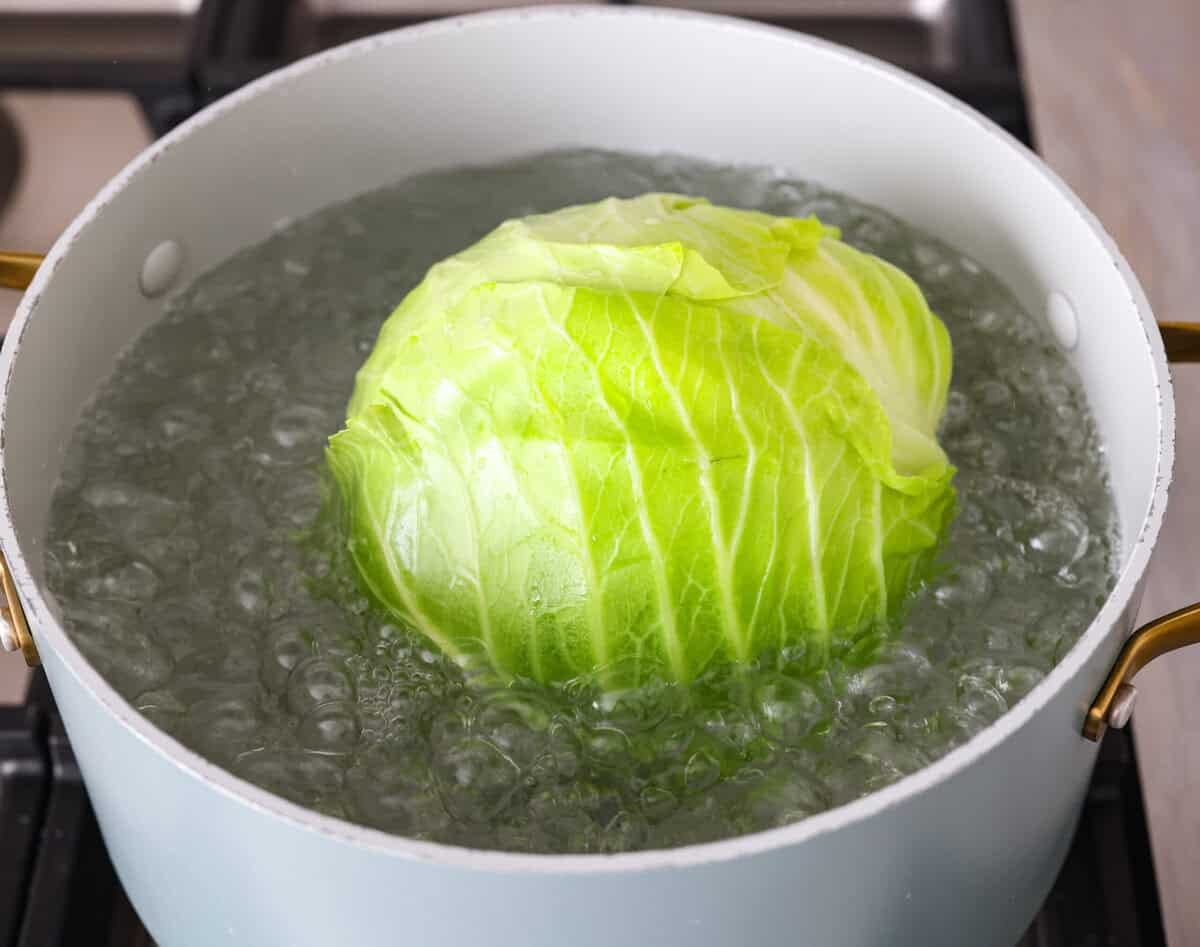 Hungarian cabbage rolls are packed with rich, hearty flavors in every bite! I know you love a good cabbage roll and can’t get enough of my Hungarian goulash, so I knew this recipe would be perfect. Angle shot of a head of cabbage in a pot of boiling water.