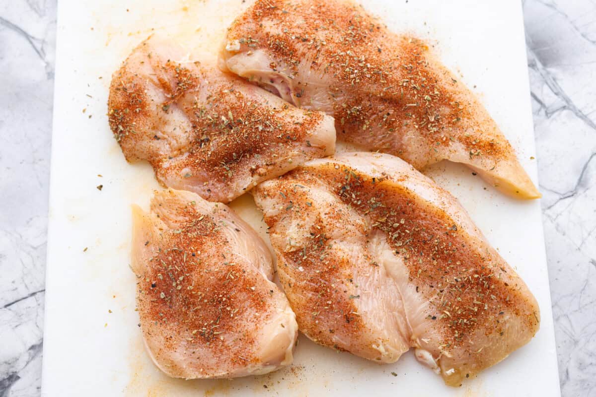 Marry Me Chicken Ramen is the ultimate comfort food mashup you didn’t know you needed! Searing the chicken first locks in moisture and flavor, then it simmers with fresh basil and tangy sun-dried tomatoes in a rich, velvety broth. Overhead shot of seasoned chicken on a cutting board.
